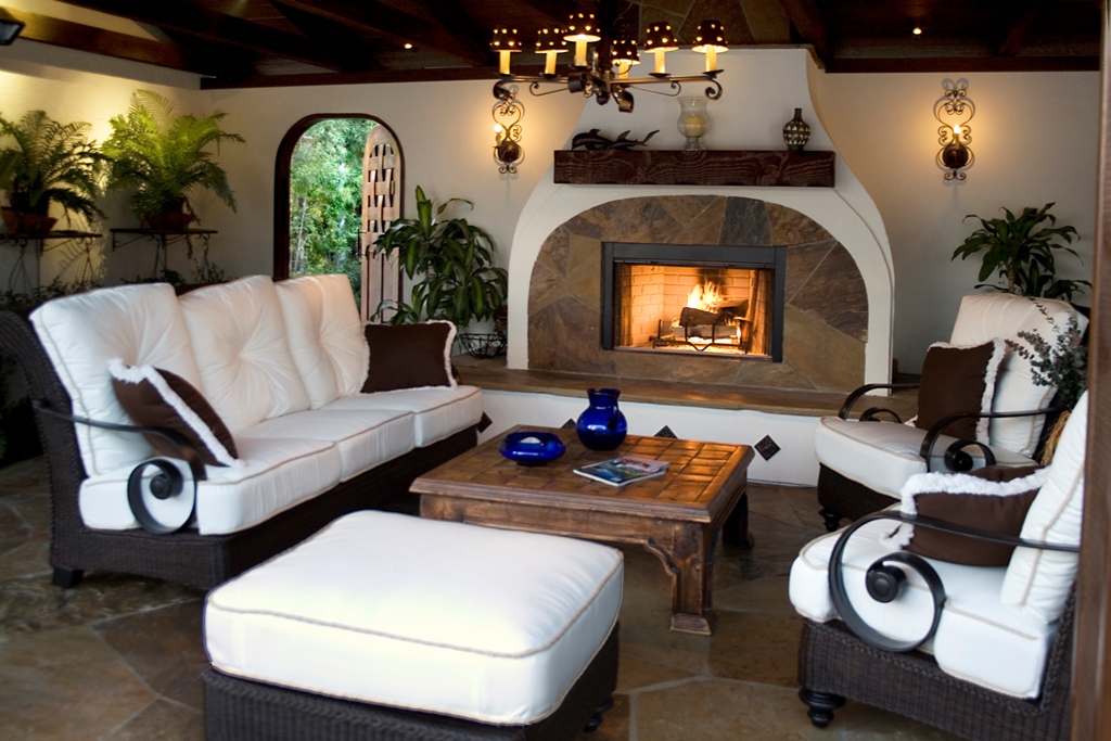 The custom door at the rear wall is matched symmetrically with one on the right. Both open up the space for fresh air to an open space behind the pavilion where a small sports court exists. Many details included wrought iron as a rustic theme to the remodel.