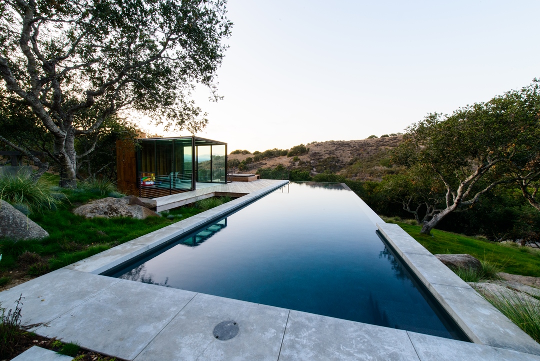 The automatic cover is completely invisible when retracted into the floor at the center of the pool.